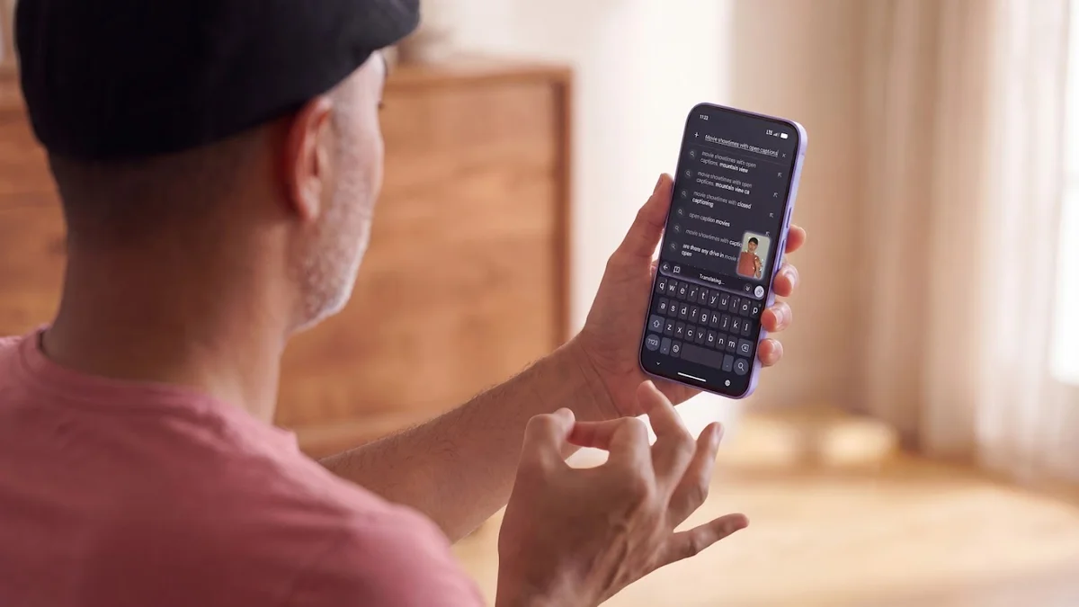 A person signs with one hand while holding a smartphone, demonstrating the Gboard sign-to-text dictation feature.