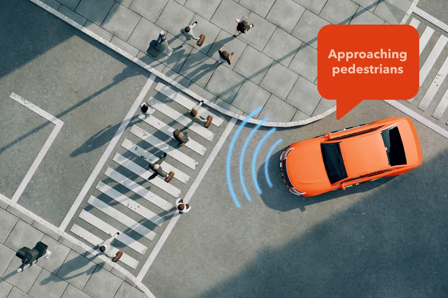 A car senses the people on a crosswalk and says, “approaching pedestrians.”